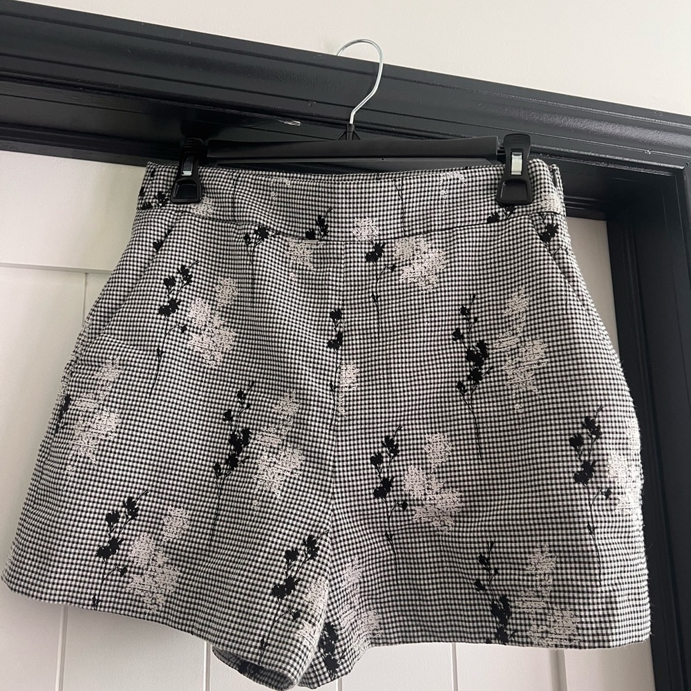 Black and white shorts with a floral design, size M